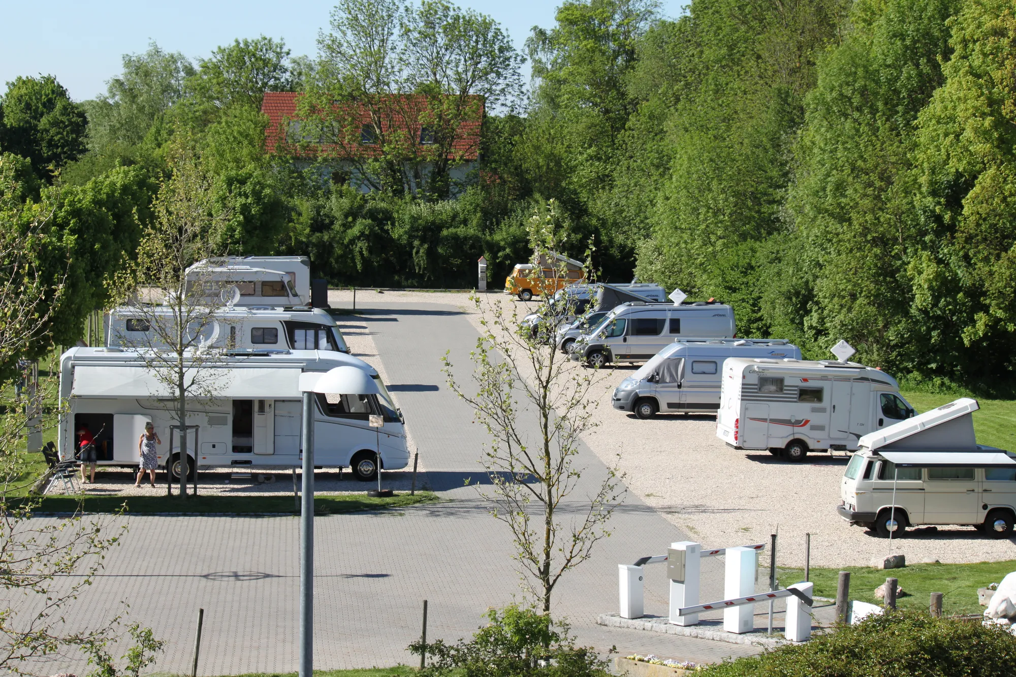 Stellplätze des Wohnmobilparks Erding mit Wohnmobilen und Stromsäulen im Vordergrund