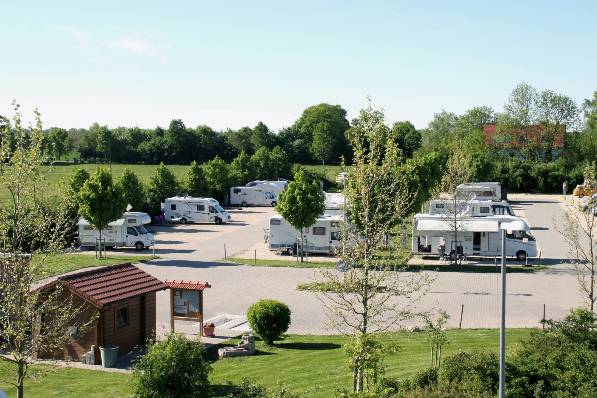 Wohnmobilpark Erding mit Kassenhäuschen im Vordergrund und Wohnmobilen auf der Stellfläche