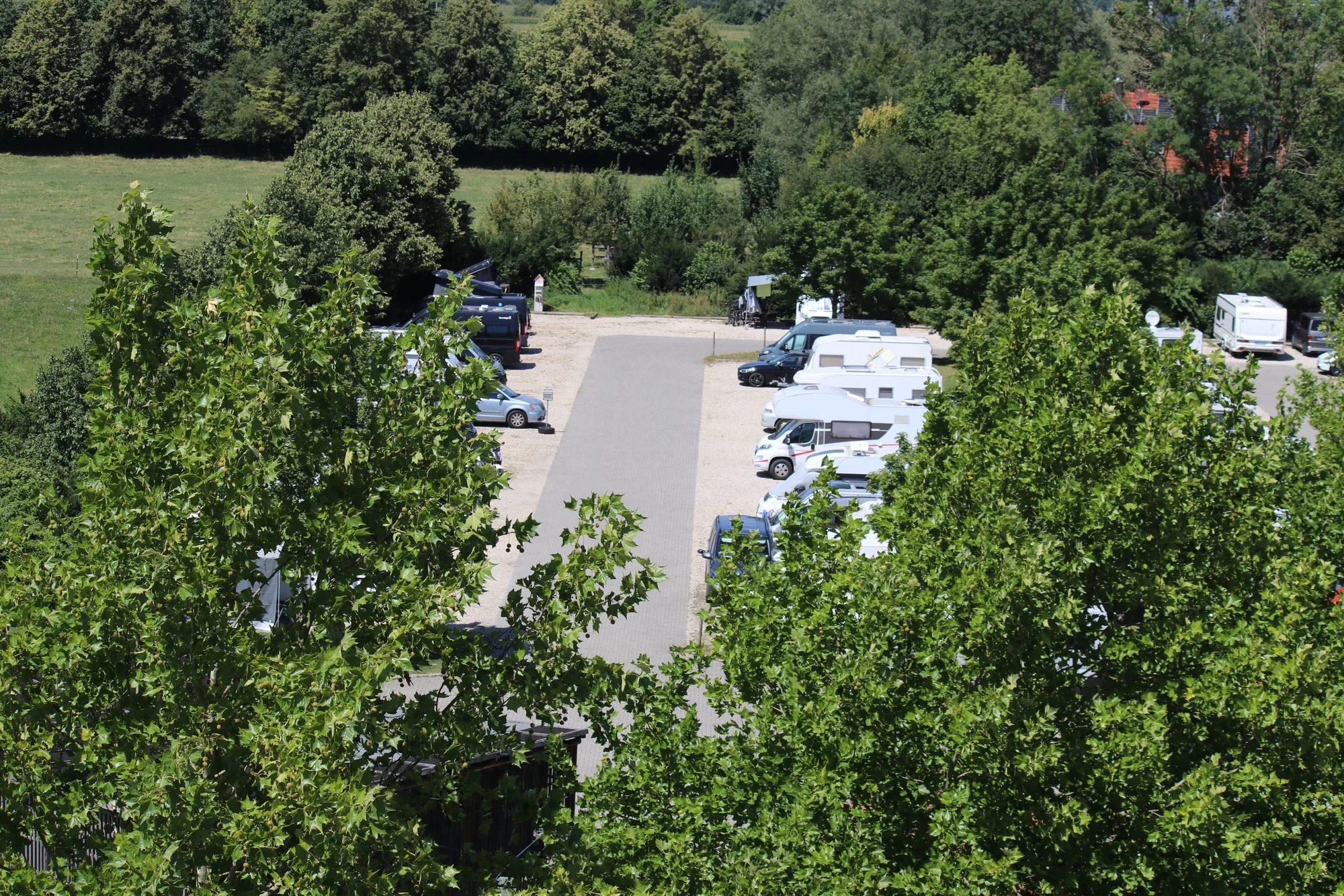 Blick von oben auf den Wohnmobilpark Erding mit Stellplätzen zwischen Bäumen und Wiesen