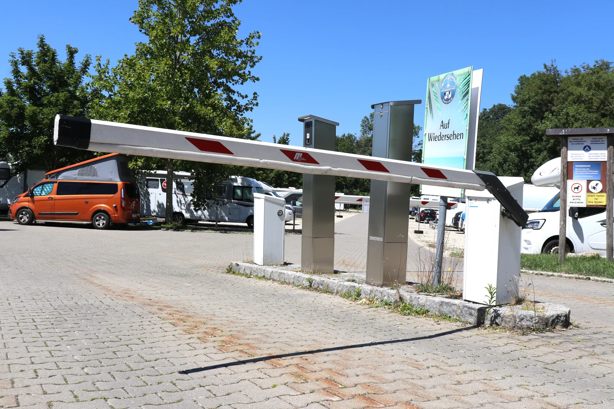 Geöffnete Ausfahrtschranke mit Wiedersehen-Schild im Wohnmobilpark Erding