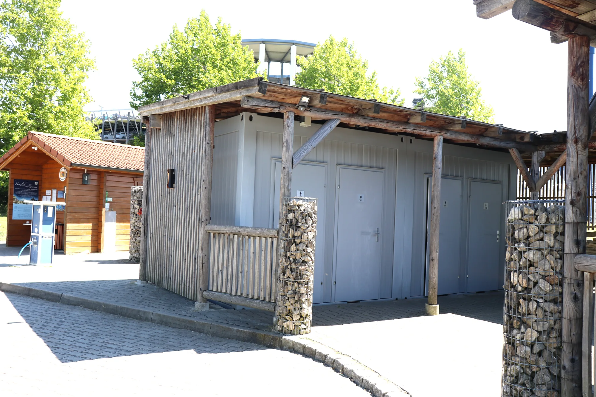Sanitärgebäude mit Duschen und WC im Wohnmobilpark Erding, Holzfassade mit Gabionen