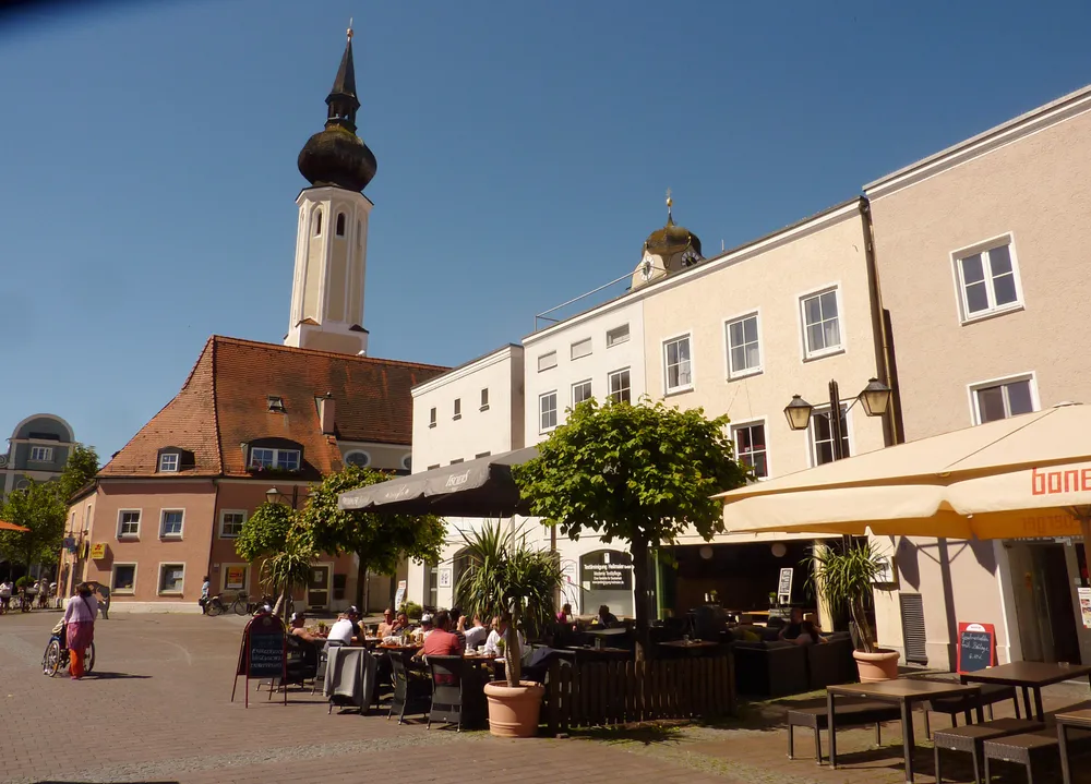 Schrannenplatz in der Erdinger Altstadt mit Kirchturm und Straßencafé
