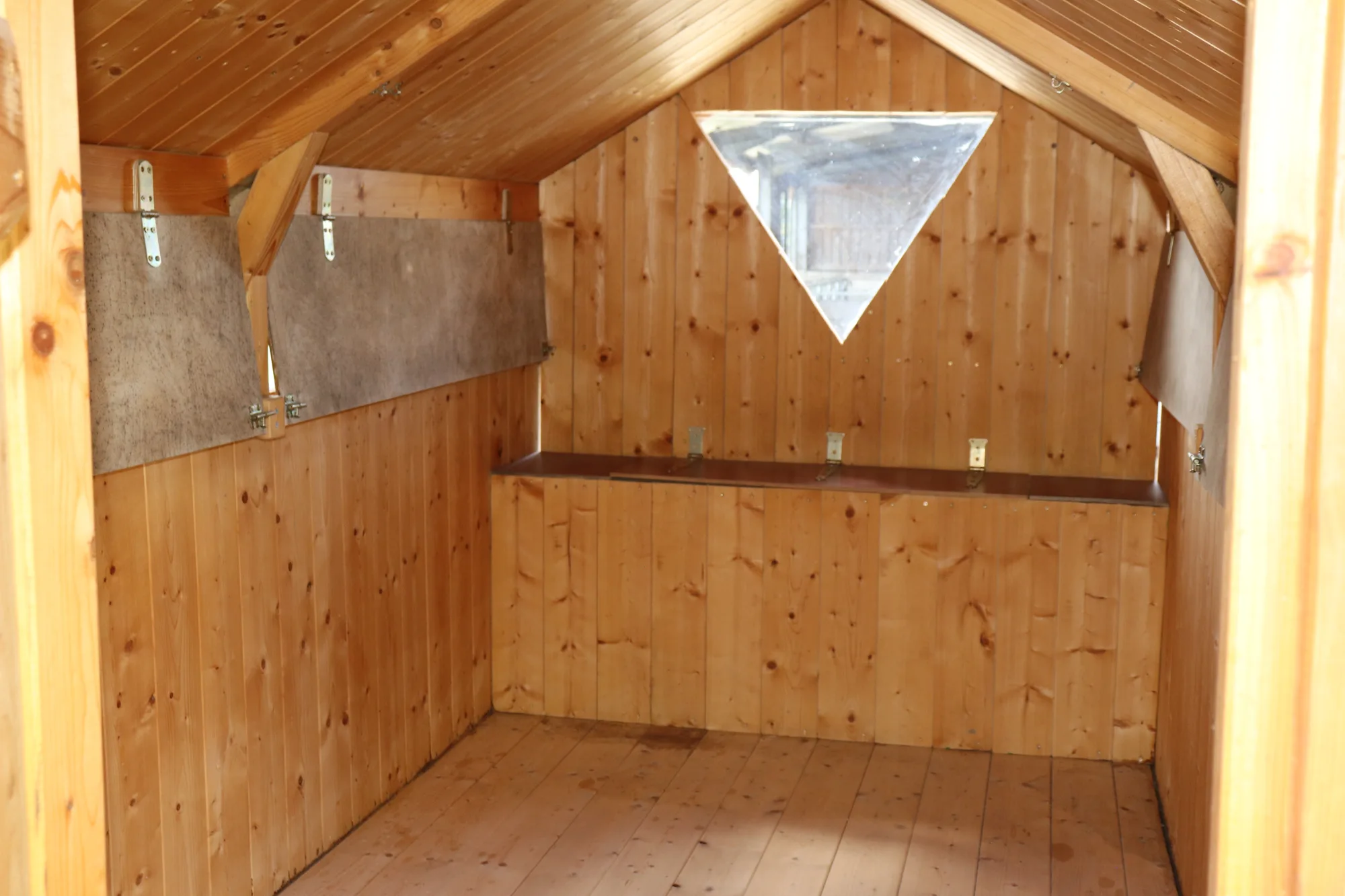 Innenraum des Holzwagens mit heller Holzverkleidung, Theke und Dreiecksfenster