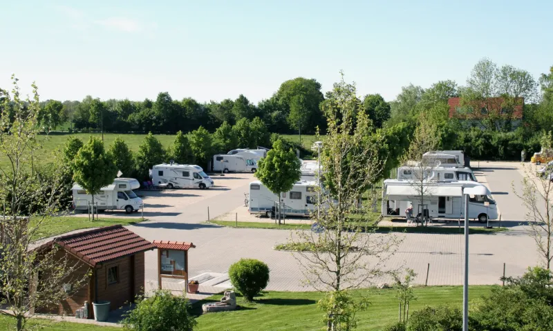 Wohnmobilpark Erding mit Kassenhäuschen im Vordergrund und Wohnmobilen auf der Stellfläche